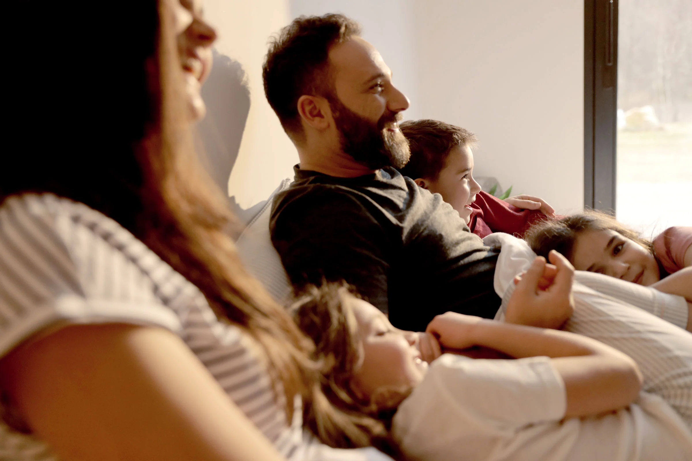 Famille regardant la télévision, grâce à nos solutions pour une tranquillité d'esprit à la maison.
