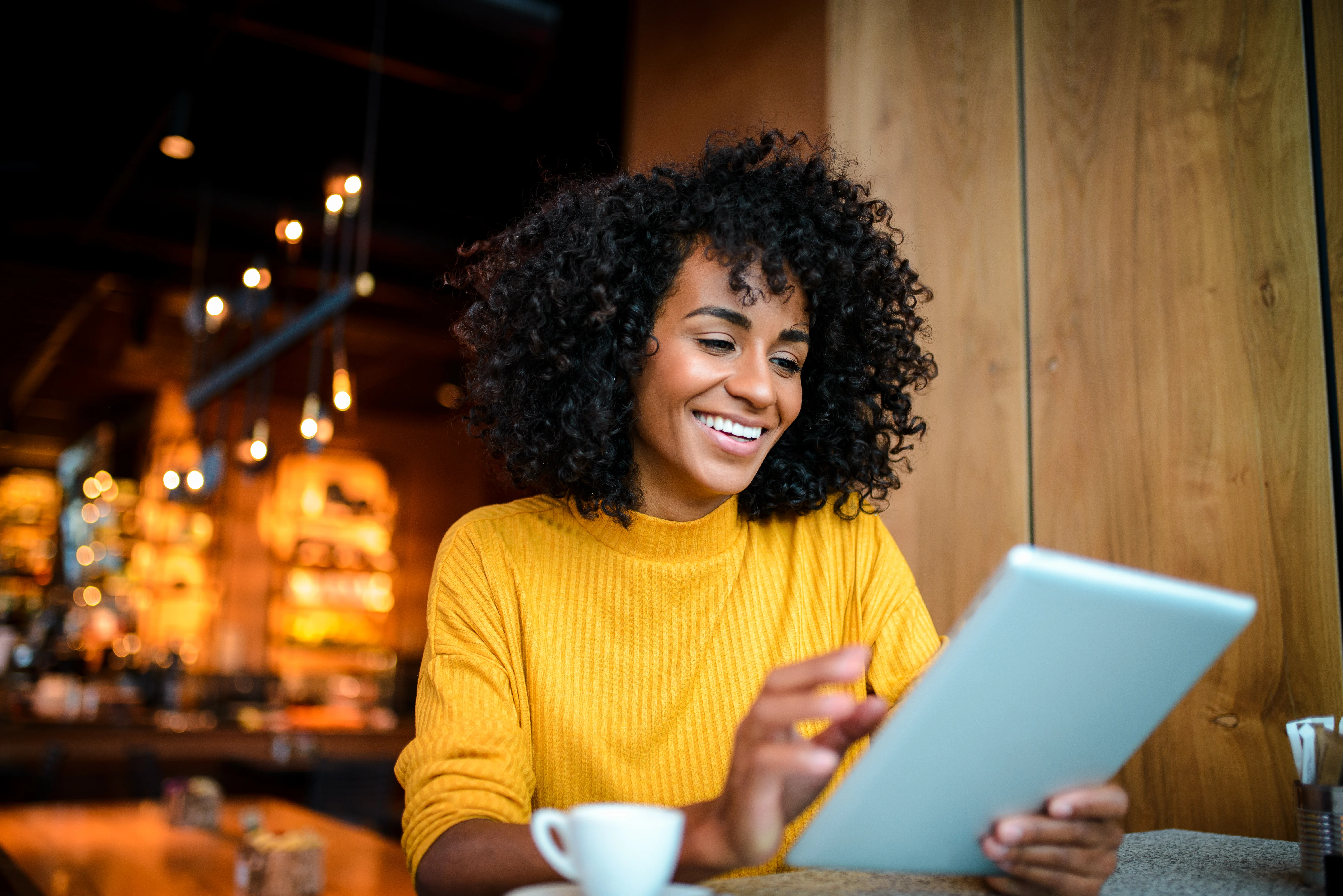 Femme d'affaires utilisant une tablette, connectée à nos solutions technologiques pour une productivité optimale.